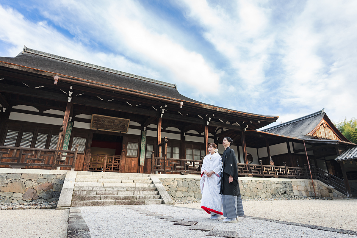 萬福寺の境内で赤ふきの白無垢と黒紋付姿の新郎新婦