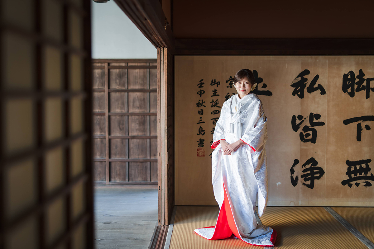 萬福寺の和室で赤ふきの白無垢を着たシｓョートヘアの新婦