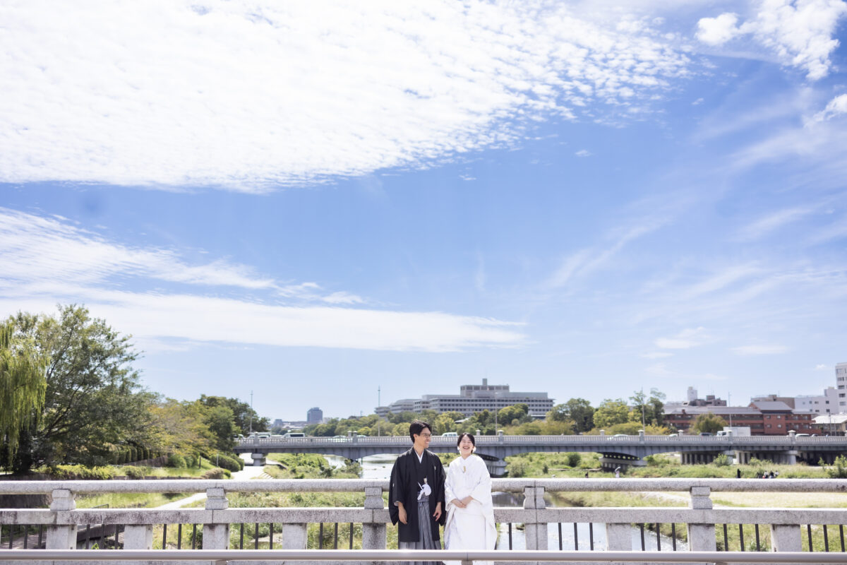 青空の下で楽しそうな新郎新婦
