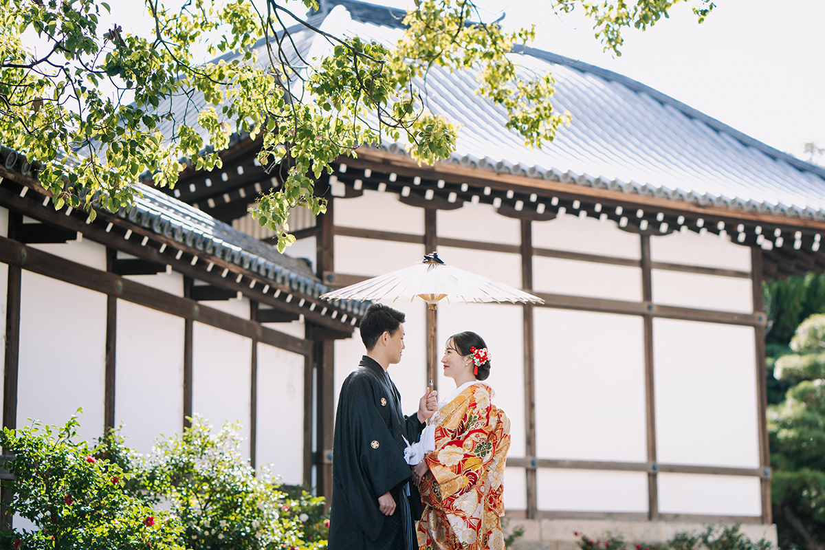 和傘の下で見つめ合う新郎新婦