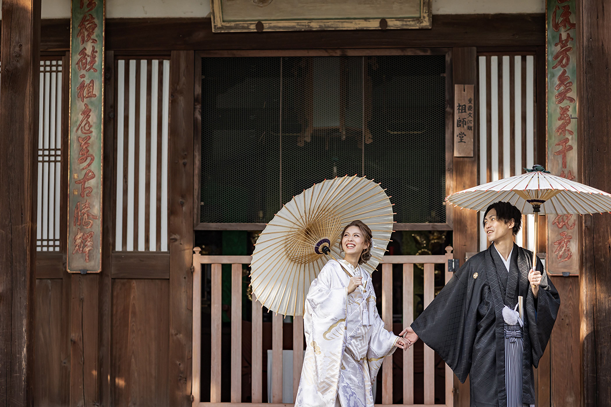 京都の萬福寺で空を見上げる和装姿の新郎と新婦