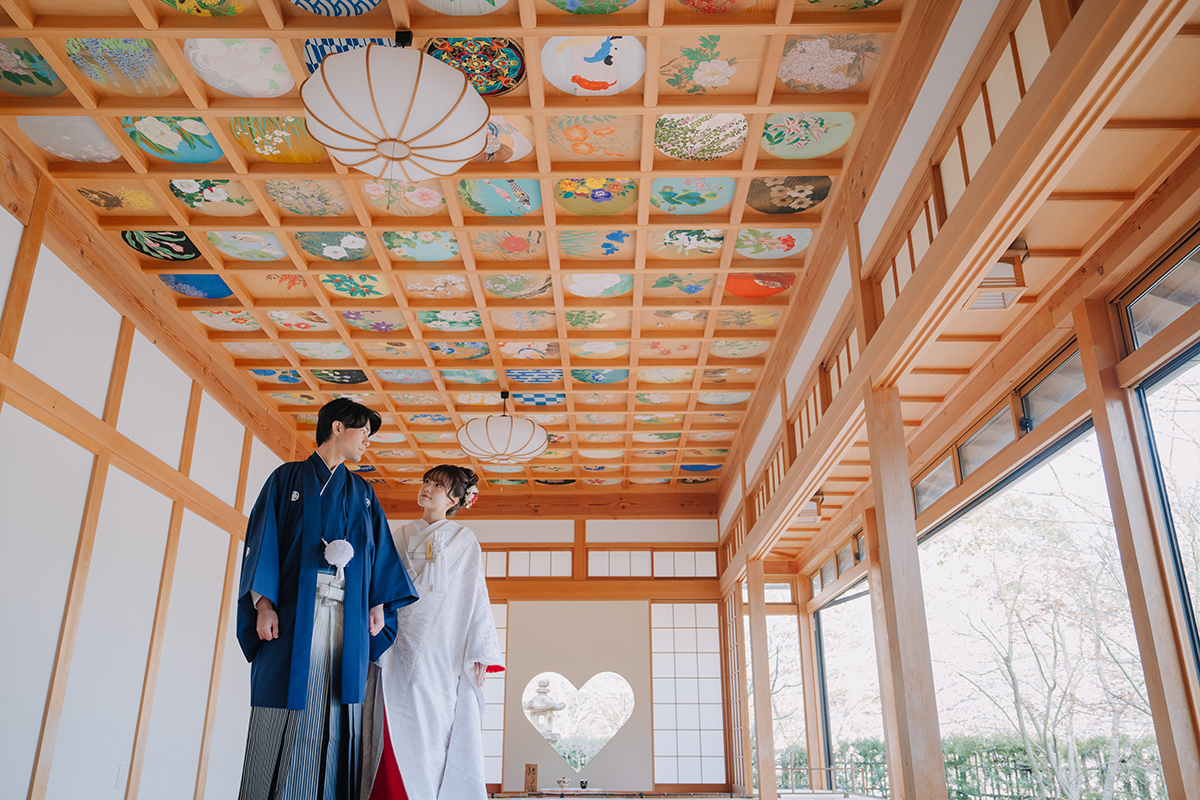 正寿院のハートの和室で赤ふきの白無垢と黒紋付姿の新郎新婦が楽しそうに笑う