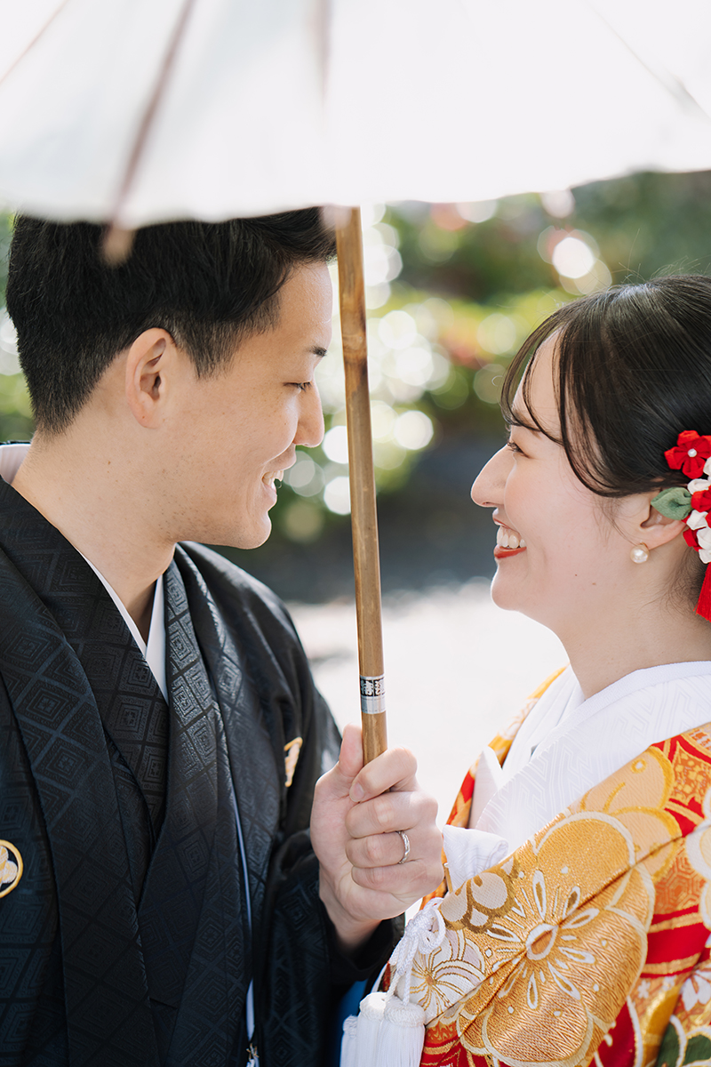相合傘で微笑み合う新郎新婦