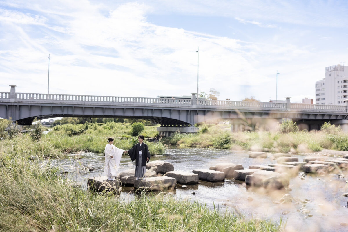 晴れ渡る青空と鴨川で婚礼和装姿の新郎新婦