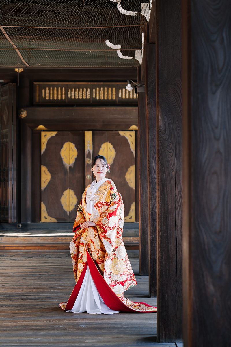 荘厳な回廊に立つ色打掛の新婦