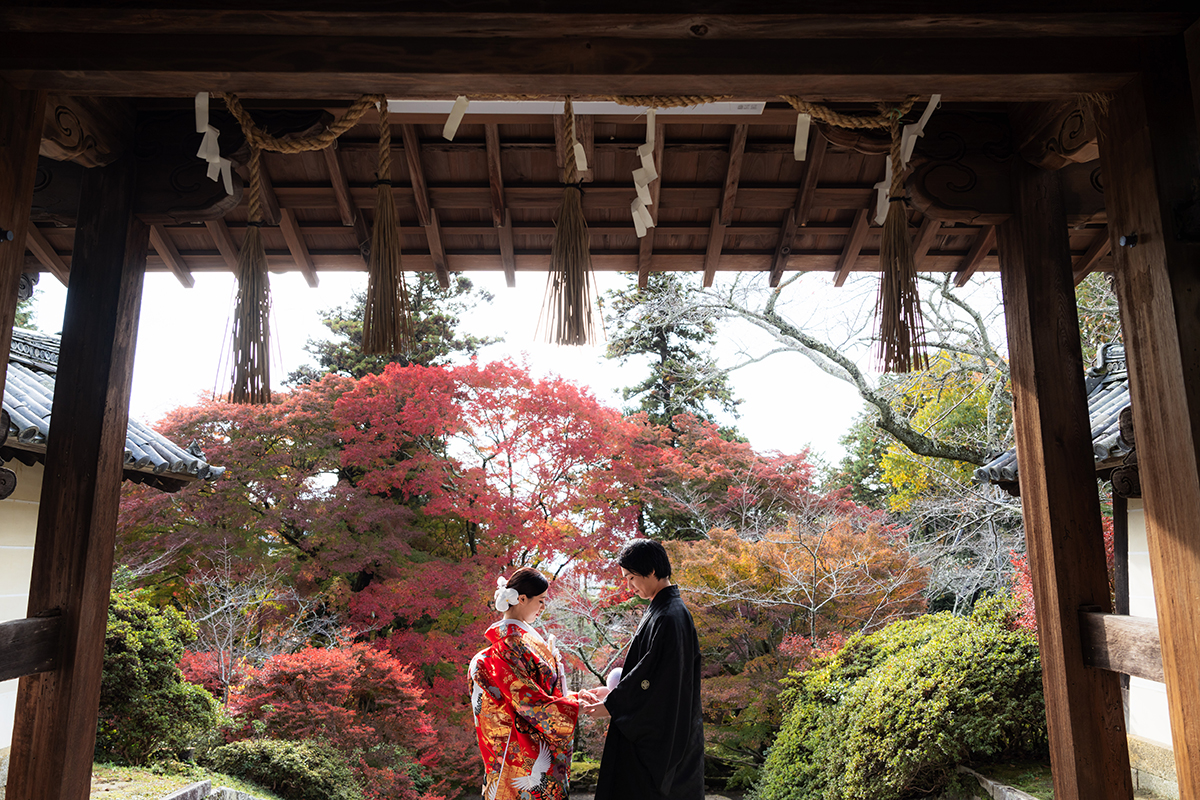 毘沙門堂（京都）で和装前撮り・フォトウェディング「薬医門で向かい合って手を繋ぐ新郎新婦」