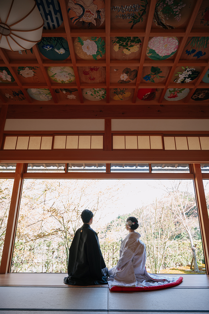 正寿院の縁側に座る赤ふき白無垢の新婦と新郎の後ろ姿
