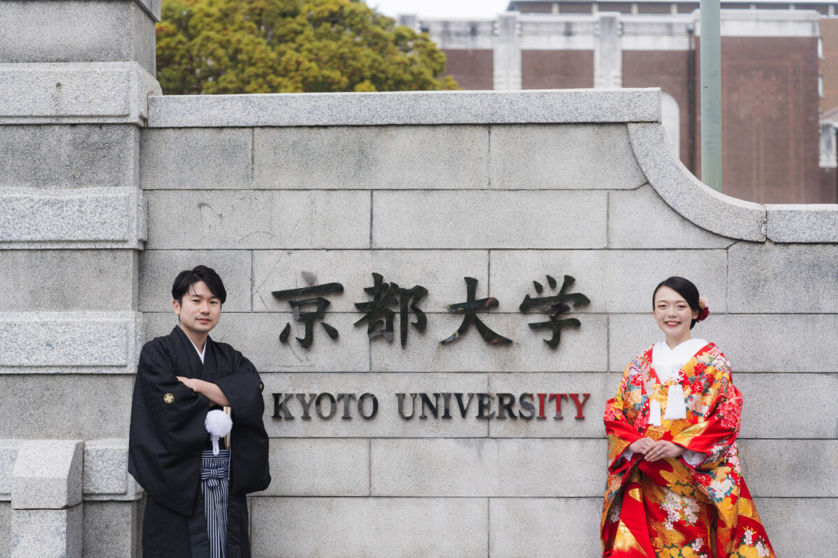 京都大学の正門前に並ぶ和装の新郎新婦