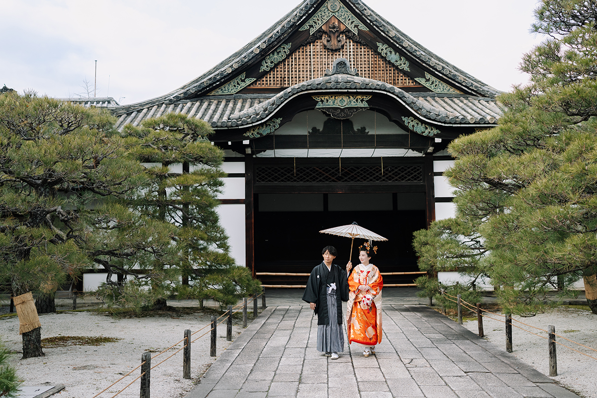 和傘を差して歩く新郎新婦