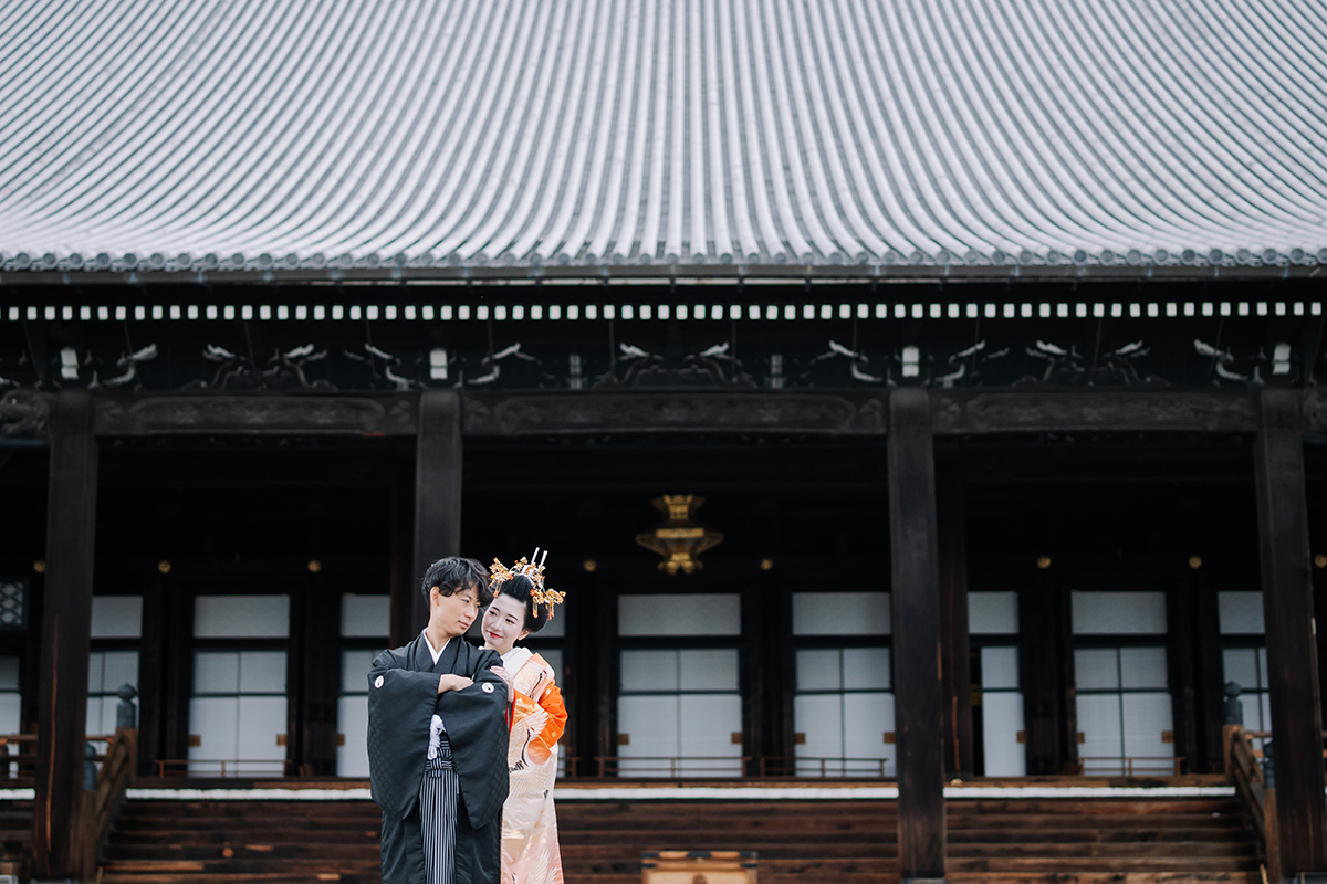 壮大な阿弥陀堂を背に寄り添う新郎新婦