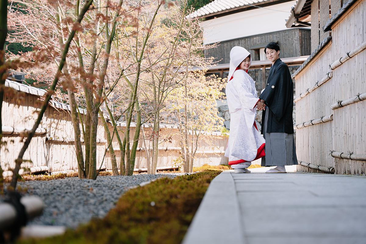 正寿院で手をつなぐ赤ふきの白無垢を着た新婦と新郎