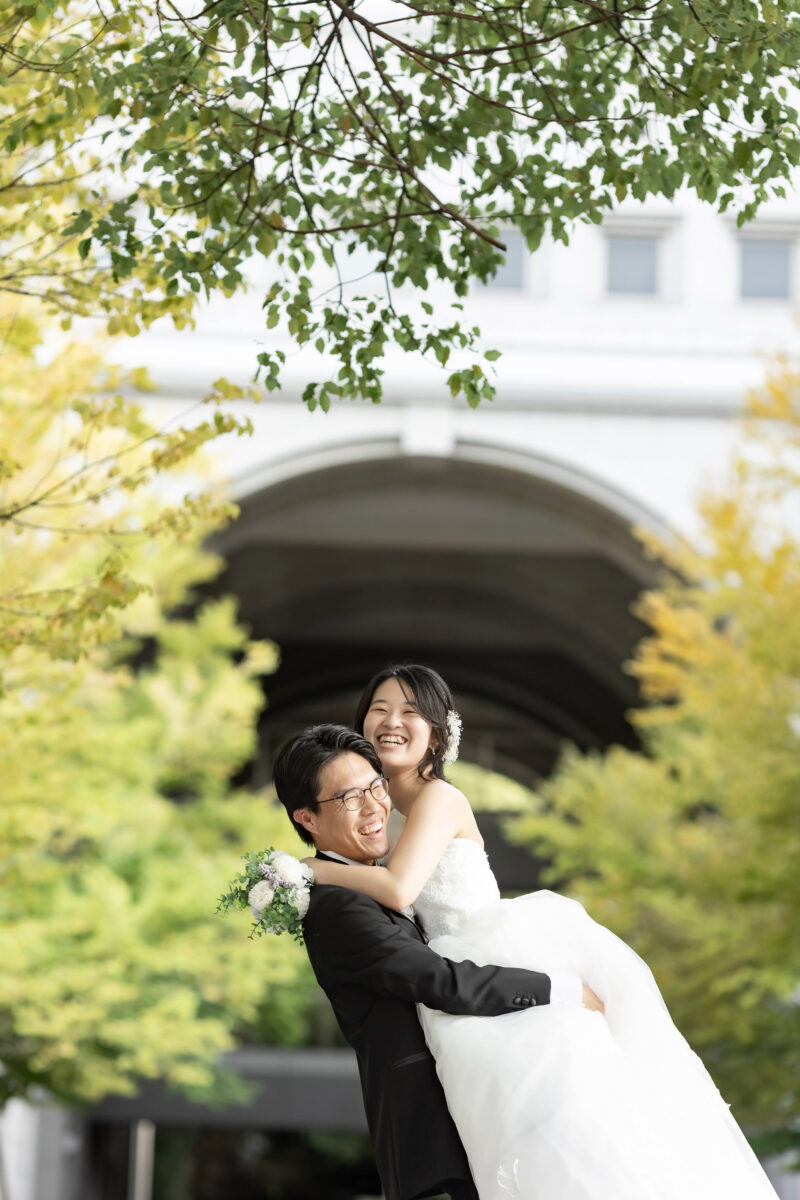 京都大学のキャンパスで抱きつきながら笑顔の新郎新婦