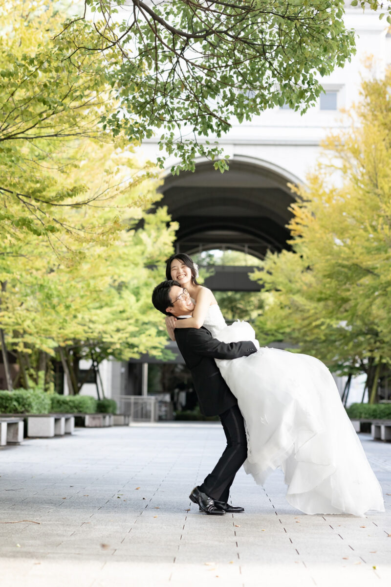京都大学のキャンパスで新婦を抱え上げる新郎