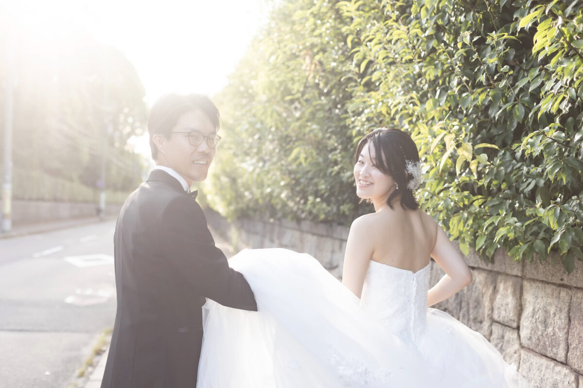 きれいな西日をバックに振り帰る新郎新婦